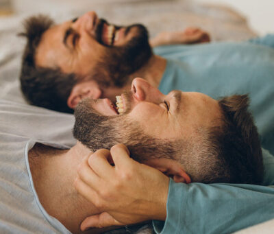 gay-male-couple-laughing-in-bed